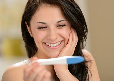 Ragazza sorridente che esamina un test di gravidanza