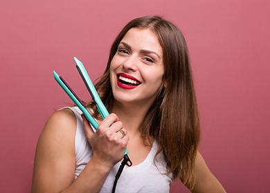 Ragazza con una piastra per capelli