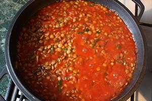 Porridge in una casseruola versata con pomodoro rosso brillante