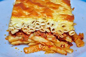 Fetta di casseruola di pasta con carne tritata su un piatto blu