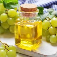 Olio di semi d'uva tra spazzole di bacche verdi