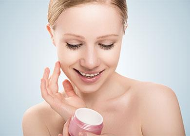 La ragazza spalma la crema per il viso