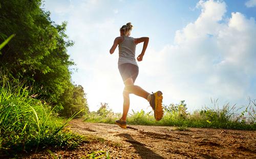 La ragazza corre lungo il sentiero verso il sole