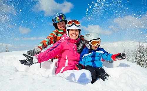 Famiglia sportiva in sella a una collina invernale