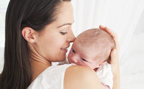 La mamma tiene un neonato con un sorriso