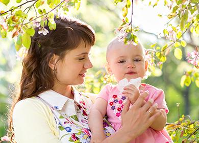 Mamma e bambino camminano tra alberi in fiore