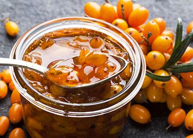 Cucchiaio in un barattolo di marmellata e un rametto di frutti di bosco