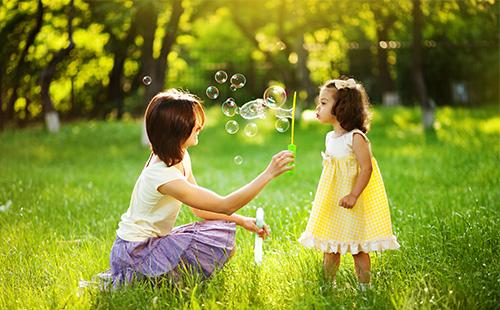 Mamma e figlia giocano con le bolle di sapone