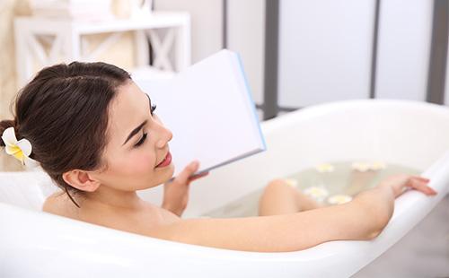 La ragazza legge mentre fa il bagno