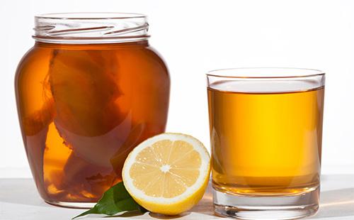 Kombucha in un barattolo, limone e una tazza con tè