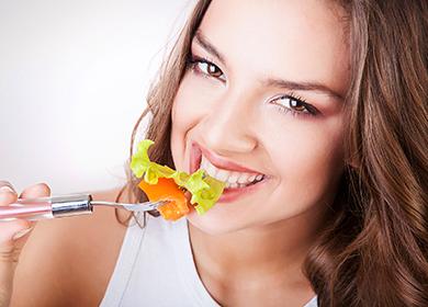 Ragazza graziosa che mangia insalata