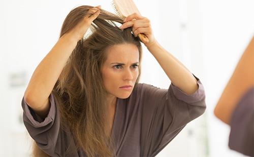 La donna esamina i suoi capelli