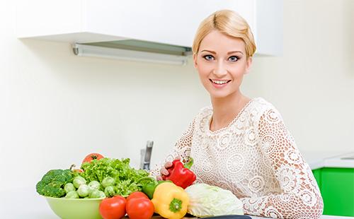 Ragazza e verdure sul tavolo