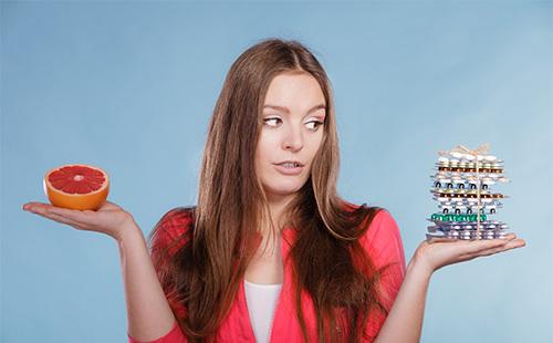 La ragazza sceglie tra pillole e cibo