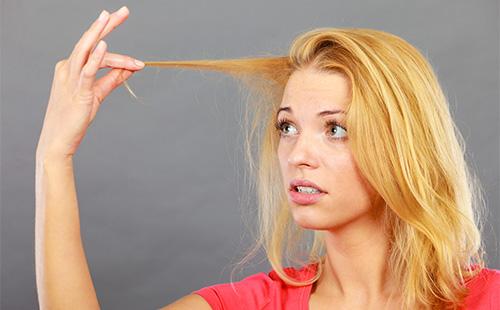 Ragazza che guarda i suoi capelli