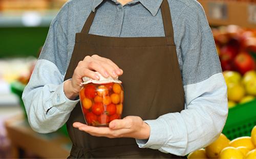 La donna tiene il barattolo di pomodori in scatola