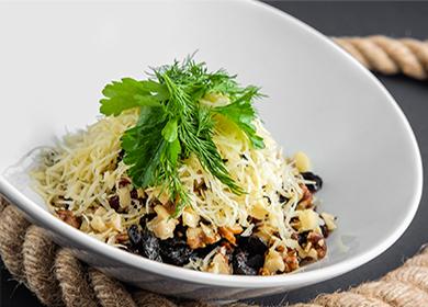 Insalata di pasta con pollo, formaggio e prugne secche in un piatto