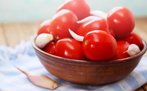 Pomodori con aglio in una tazza di legno