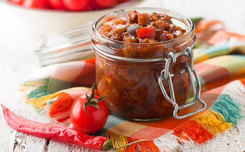 Vaso con zucchine in scatola, pomodori e peperoncino