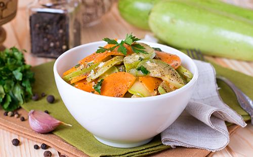 Zucchine con carote, aglio ed erbe in un piatto