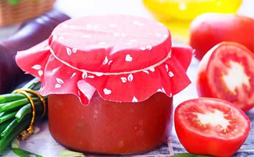 Passata di pomodoro in un barattolo e pomodori a fette