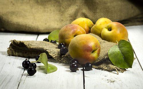 Albicocche e ribes nero su un tavolo di legno