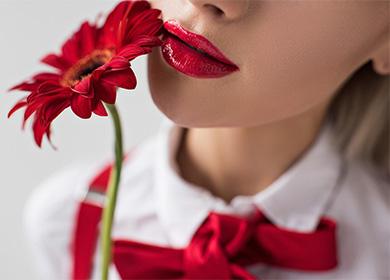 Ragazza con una gerbera rossa