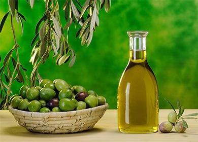 Olio d'oliva in una bottiglia e un piatto di olive