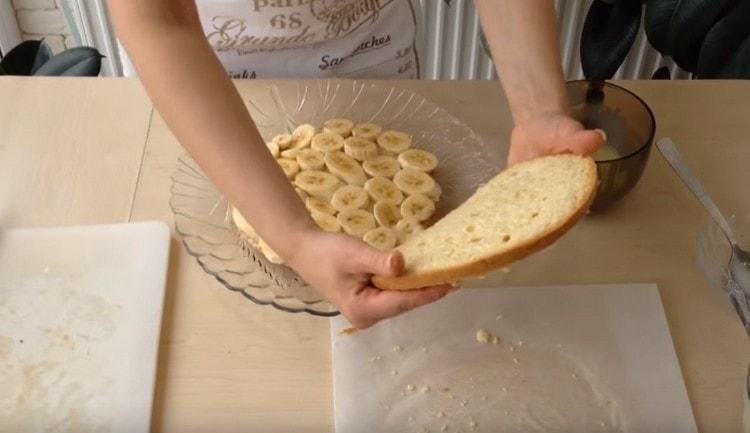 Metti uno strato di banane sulla torta inferiore e coprila con un secondo.