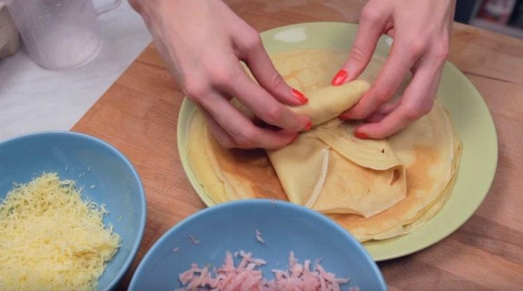 Mettiamo il ripieno sul bordo del pancake e lo avvolgiamo con una busta.