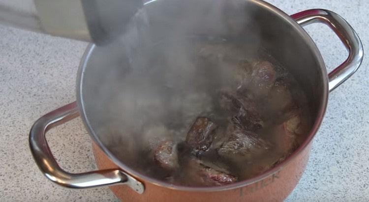 Quindi trasferire la carne nella padella e versare acqua bollente.