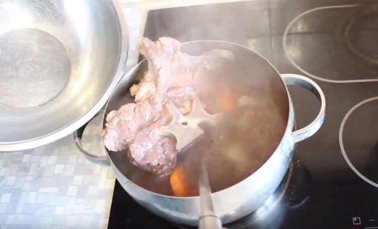 Carne e verdure pronte vengono estratte dal brodo.