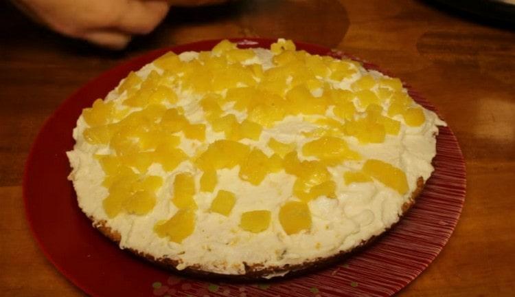 Ungere la prima parte della torta con la panna e cospargere di ananas.