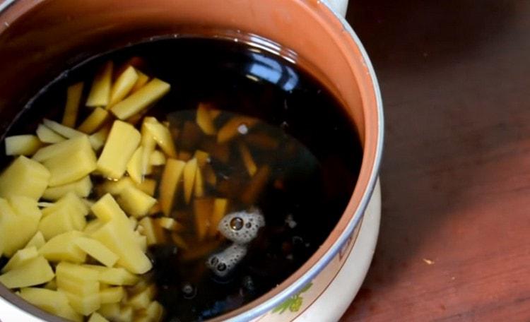 Metti le patate in una pentola d'acqua da sotto i funghi, aggiungi più acqua e metti a fuoco.