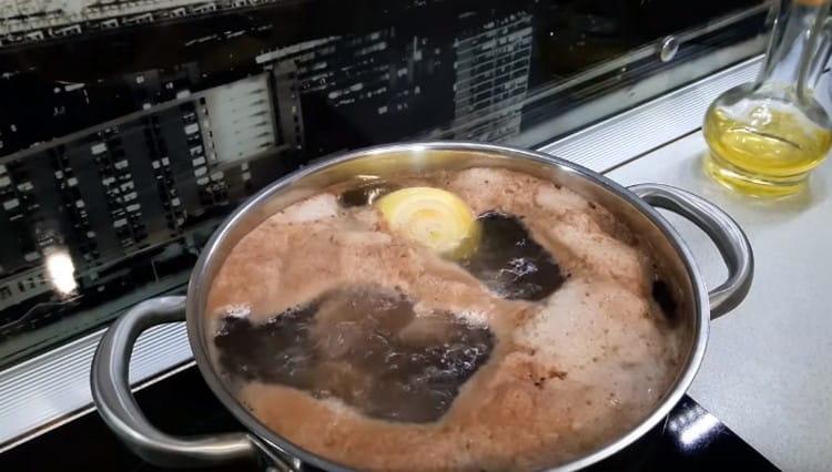 Mettiamo la carne in una padella, versiamo la soda, aggiungiamo carote e cipolle, portiamo a ebollizione.