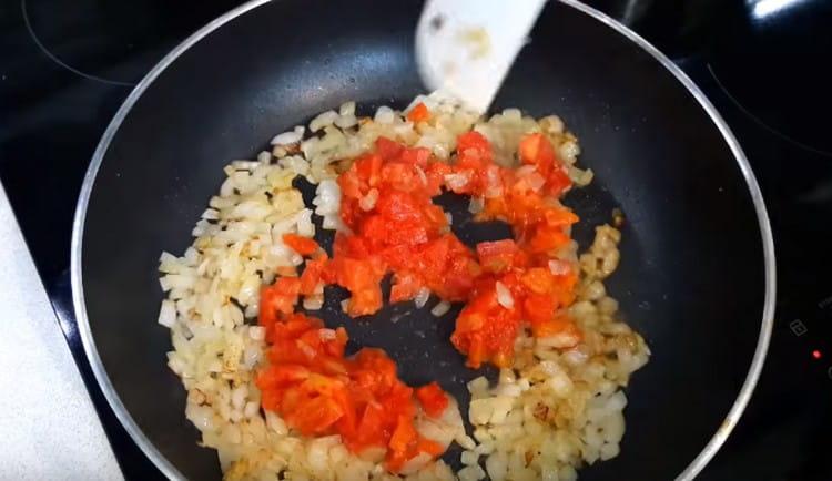 Aggiungi i pomodori tritati alla cipolla nella padella.