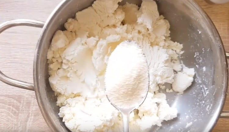 Impastare la ricotta, aggiungere lo zucchero e la semola.