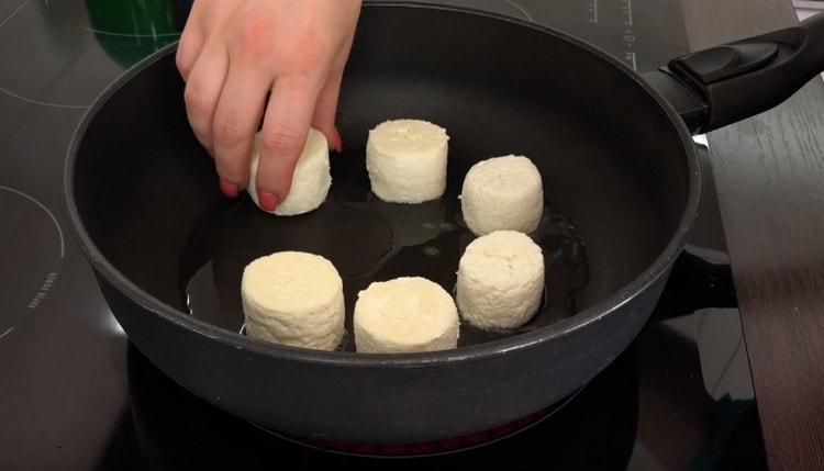 Riscaldiamo la padella con olio vegetale e distribuiamo le torte di formaggio.