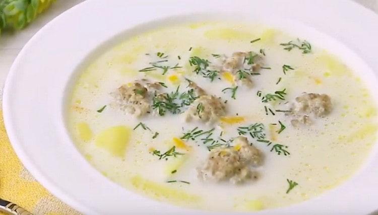 Al momento di servire, la zuppa di formaggio con le polpette può essere cosparsa di verdure tritate finemente.