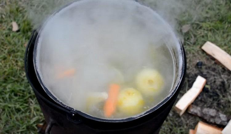 Posiamo le teste, le code, le pinne in acqua bollente, aggiungiamo carote e cipolle.