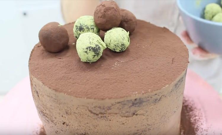 In cima alla torta al biscotto al cioccolato, puoi cospargere il cacao e decorare con decorazioni finite.