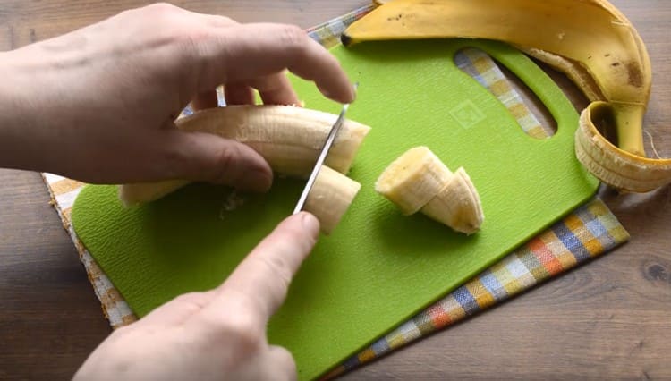 Tagliare la banana a pezzi e inviarla nella ciotola del frullatore.