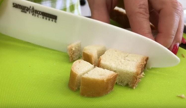 Per preparare i crostini, tagliare la pagnotta in un cubo.