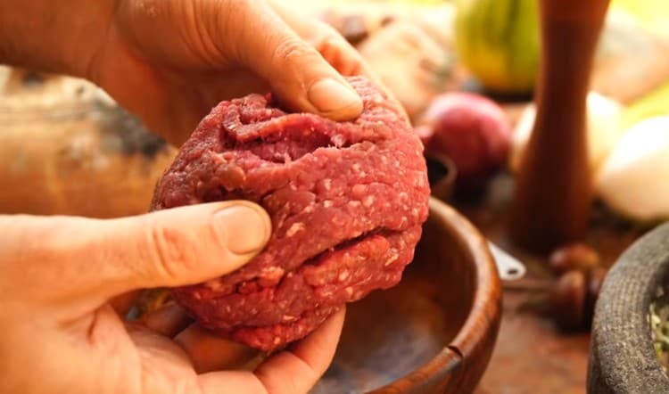 Torcere la carne attraverso un tritacarne.