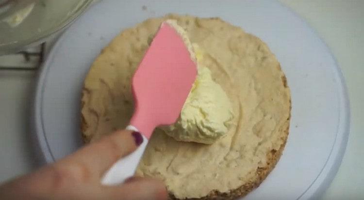 Ungere la prima torta con crema bianca.