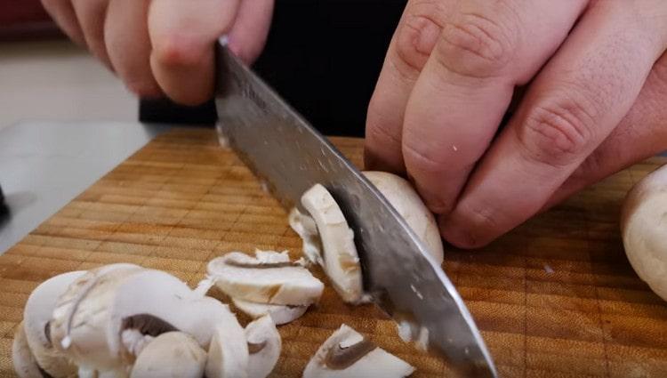 Tagliamo i funghi prataioli a fettine sottili.