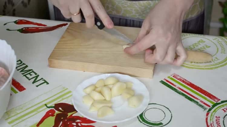 Per cuocere le cosce di pollo nel forno, tritare l'aglio