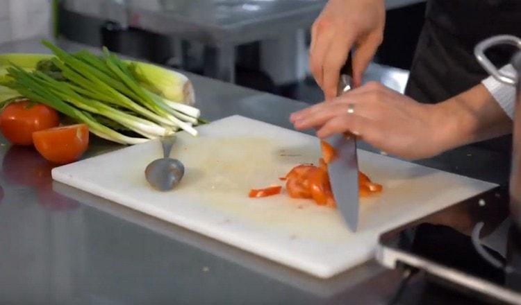 Tagliare il pomodoro e aggiungerlo alla padella.