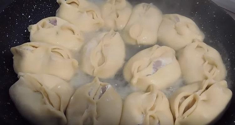 Aggiungi acqua nella padella, copri e cuoci il piatto.