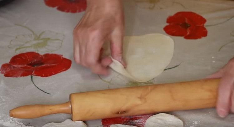 Arrotolare l'impasto in una salsiccia, tagliarlo a pezzi e arrotolarli ciascuno con un mattarello.